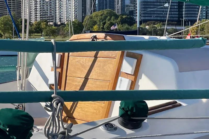 Slide: The Image of Hunter 30 sailboat from 1978 docked with city skyline in background. - 6