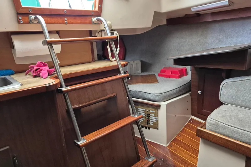 Slide: The Image of Interior of a 1978 Hunter 30 sailboat with wooden ladder and cozy seating area. - 8