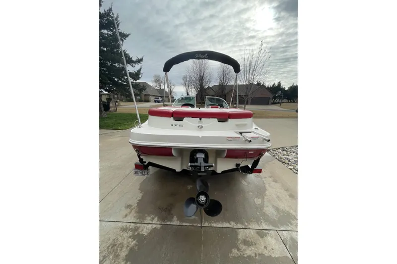 Slide: The Image of 2011 Sea Ray 175 Sport boat, rear view, parked on driveway under cloudy sky. - 5