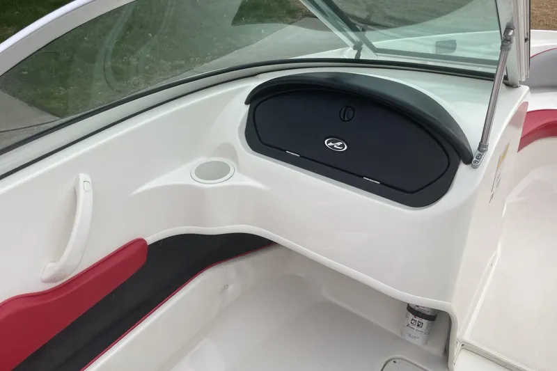 Slide: The Image of 2011 Sea Ray 175 Sport boat interior with red and white seating, cup holder, and dashboard. - 7