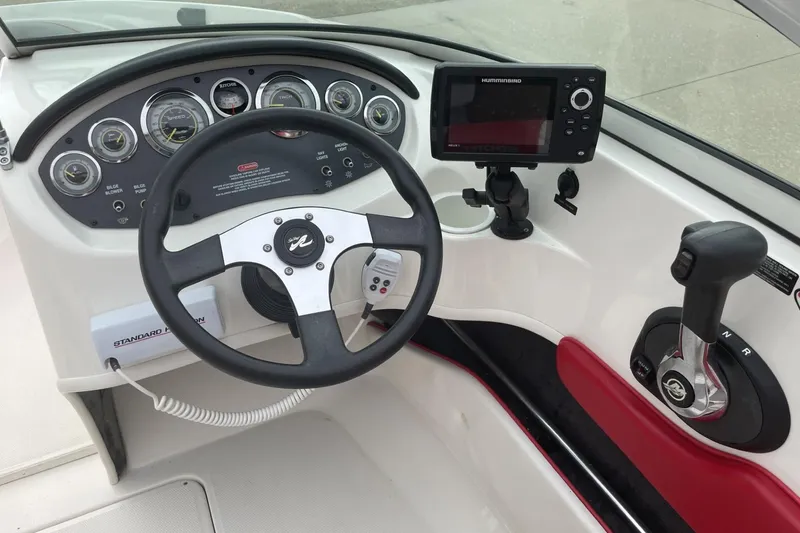 Slide: The Image of 2011 Sea Ray 175 Sport dashboard with steering wheel, gauges, and navigation system. - 8