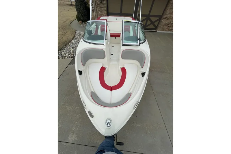 Slide: The Image of 2011 Sea Ray 175 Sport boat with red and gray interior, parked on concrete driveway. - 9