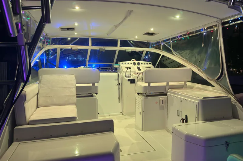 Slide: The Image of 2001 Cabo 35 Express boat interior with seating and control panel, illuminated at night. - 14