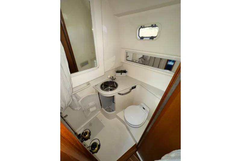 Slide: The Image of Compact bathroom in 2001 Cabo 35 Express boat with sink, toilet, and mirror. - 5