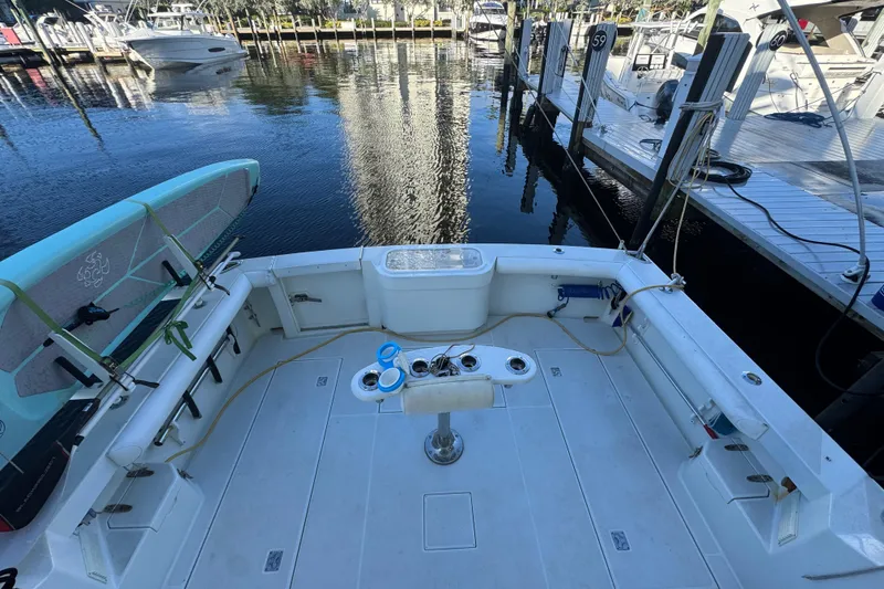 Slide: The Image of 2001 Cabo 35 Express boat deck with fishing setup, docked at marina. - 7