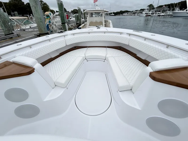 Slide: The Image of 2025 HCB 48 Campeon boat with luxurious white seating in a marina. - 13