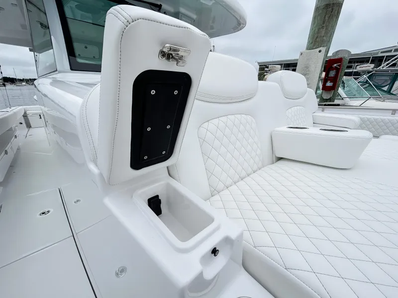 Slide: The Image of 2025 HCB 48 Campeon boat with luxurious white quilted seating and storage compartment. - 17