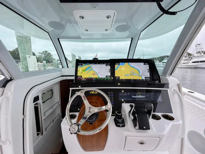 Slide: The Image of 2025 HCB 48 Campeon boat helm with dual navigation screens and modern controls. - 22