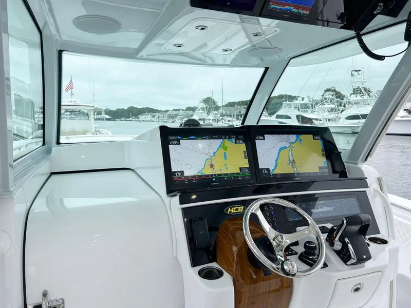 Slide: The Image of Interior of 2025 HCB 48 Campeon boat with dual navigation screens and steering wheel. - 23
