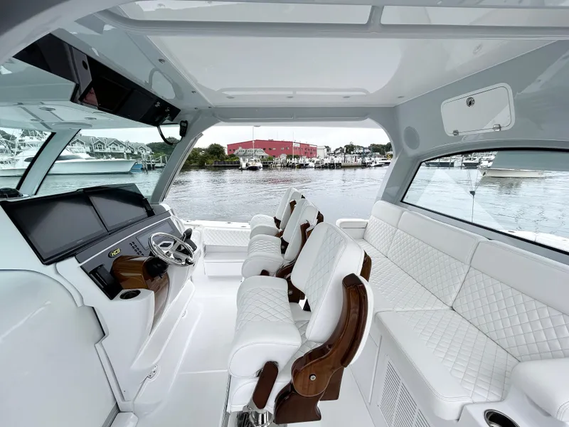 Slide: The Image of Luxurious interior of 2025 HCB 48 Campeon boat with white seating and modern dashboard. - 24