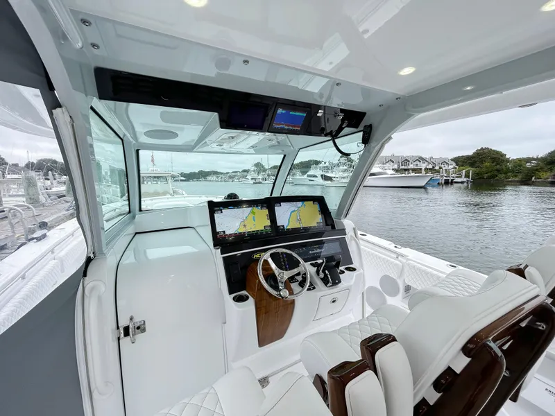 Slide: The Image of 2025 HCB 48 Campeon boat cockpit with advanced navigation system and luxurious seating. - 26