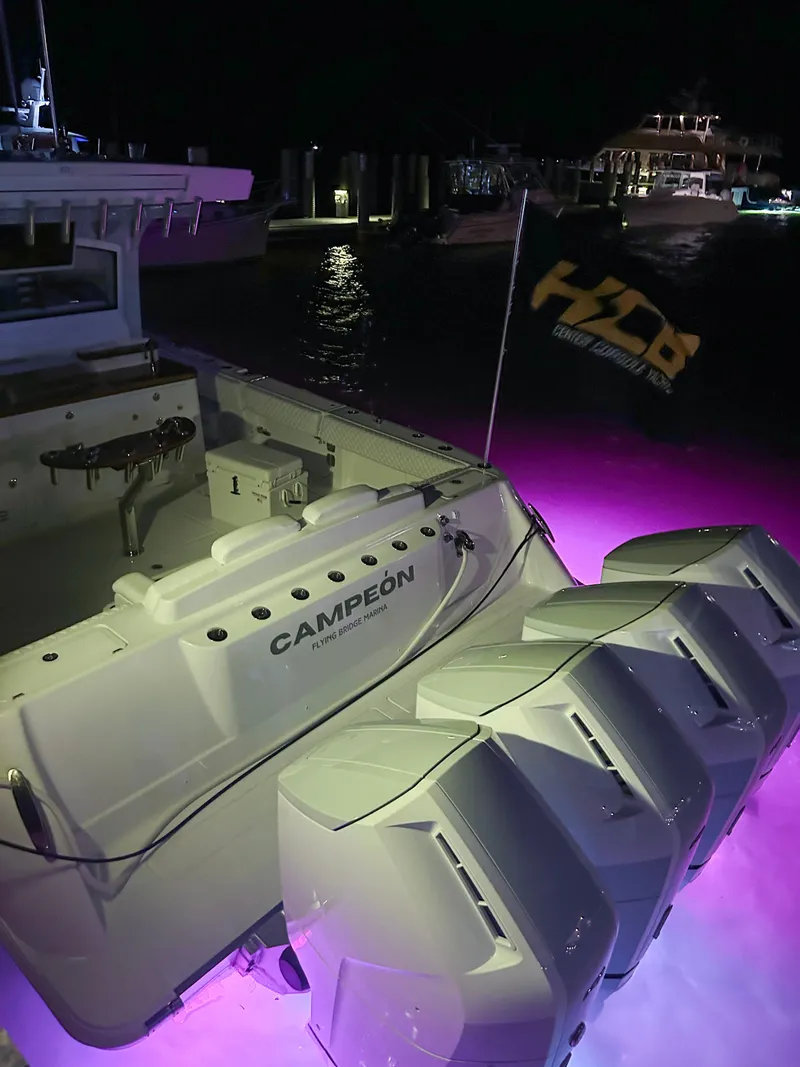 Slide: The Image of HCB 48 CAMPEON 2025 boat with purple underwater lights at night. - 80
