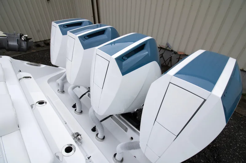 Slide: The Image of 2025 HCB 42 Lujo boat with four powerful outboard engines, docked outdoors. - 2