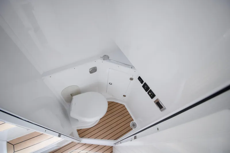 Slide: The Image of Interior of 2025 HCB 42 Lujo boat, featuring a compact bathroom with wooden accents. - 35