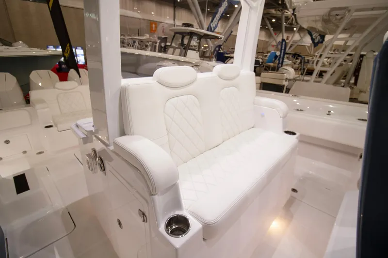 Slide: The Image of Interior view of 2025 HCB 42 Lujo boat, featuring sleek white seating and storage compartment. - 44