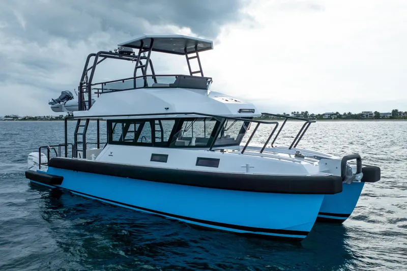 Slide: The Image of 2023 Vandal 46 Explorer catamaran on open water under cloudy skies. - 11