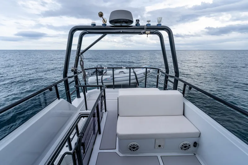 Slide: The Image of 2023 Vandal 46 Explorer yacht deck with seating, ocean view, and inflatable boat. - 22