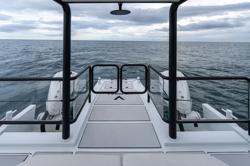 Slide: The Image of 2023 Vandal 46 Explorer yacht deck with ocean view, featuring dual outboard motors. - 31