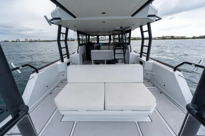 Slide: The Image of 2023 Vandal 46 Explorer yacht interior with white seating, open water view. - 33