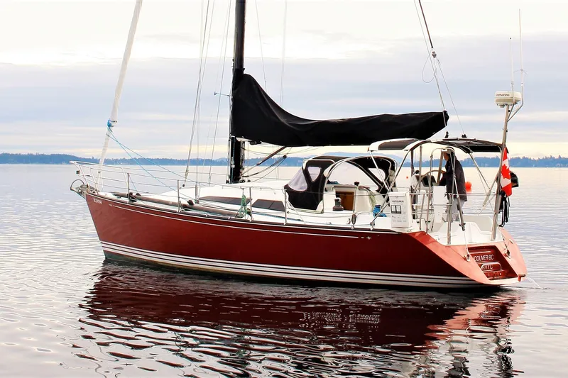The Image of Red C&C 110 sailboat from 2005 on calm water, featuring a sleek design. - 0