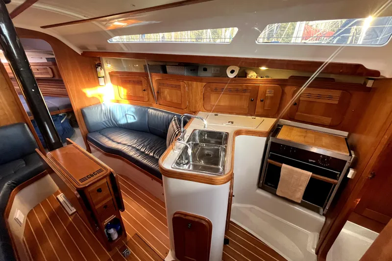 Slide: The Image of Interior of 2005 C&C 110 sailboat with wood finish, kitchen, and seating area. - 11