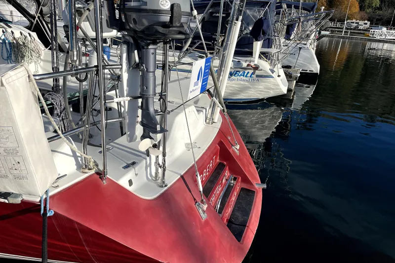 Slide: The Image of Red C&C 110 sailboat from 2005 docked at marina, featuring outboard motor. - 45