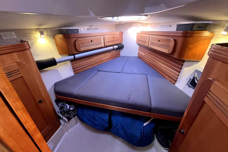 Slide: The Image of Cozy cabin interior of a 2005 C&C 110 sailboat with wooden storage and cushioned bed. - 5