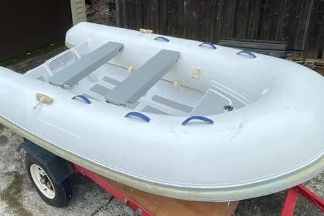Slide: The Image of Inflatable C&C 110 boat on trailer, 2005 model, white with gray seats. - 53