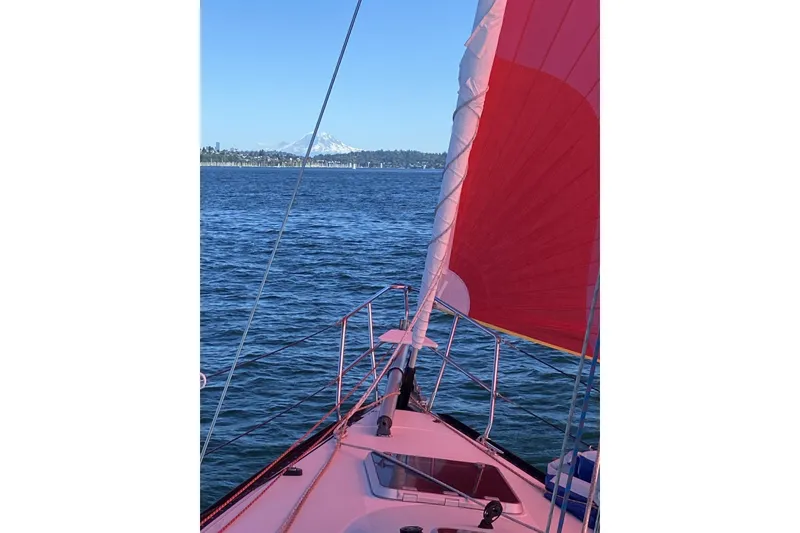 Slide: The Image of Sailing on a C&C 110 yacht with red sail, mountain view in background. - 56