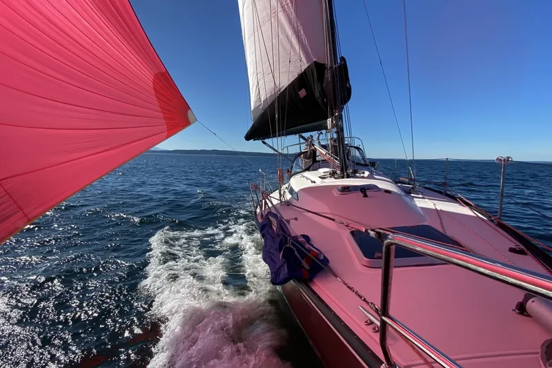 Slide: The Image of Sailing on a 2005 C&C 110 yacht with vibrant red spinnaker on open sea. - 57