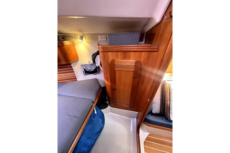 Slide: The Image of Cozy cabin interior of 2005 C&C 110 sailboat with wooden cabinetry and bedding. - 6