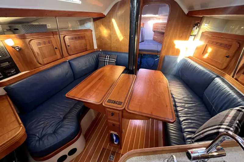 Slide: The Image of Luxurious 2005 C&C 110 yacht interior with blue leather seating and wooden table. - 7