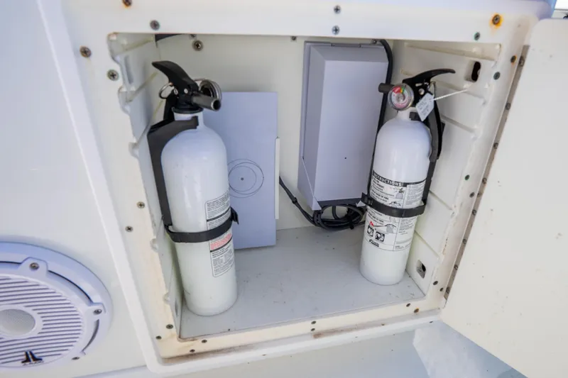 Slide: The Image of Storage compartment with fire extinguishers on a 2016 Yellowfin 36 Offshore boat. - 48