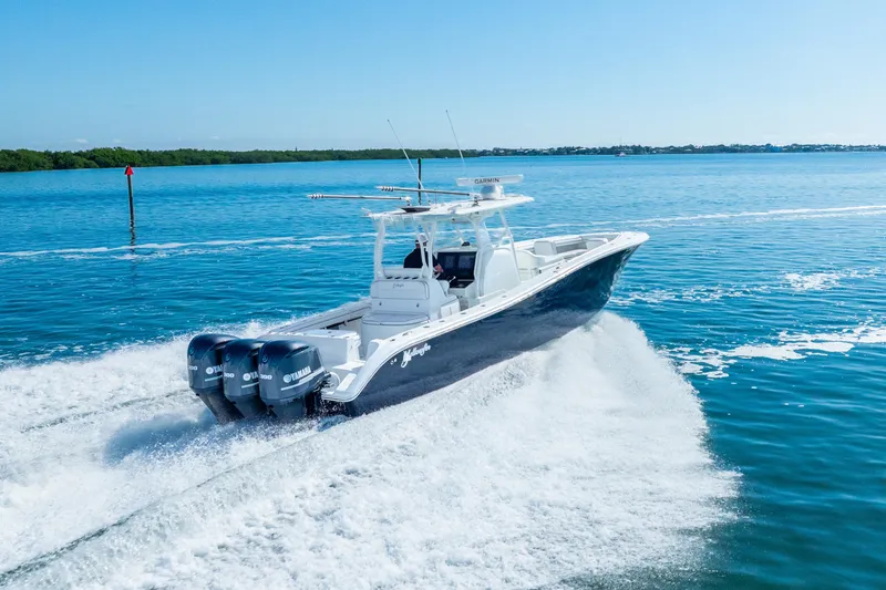 Slide: The Image of 2016 Yellowfin 36 Offshore boat cruising on open water with triple Yamaha engines. - 5