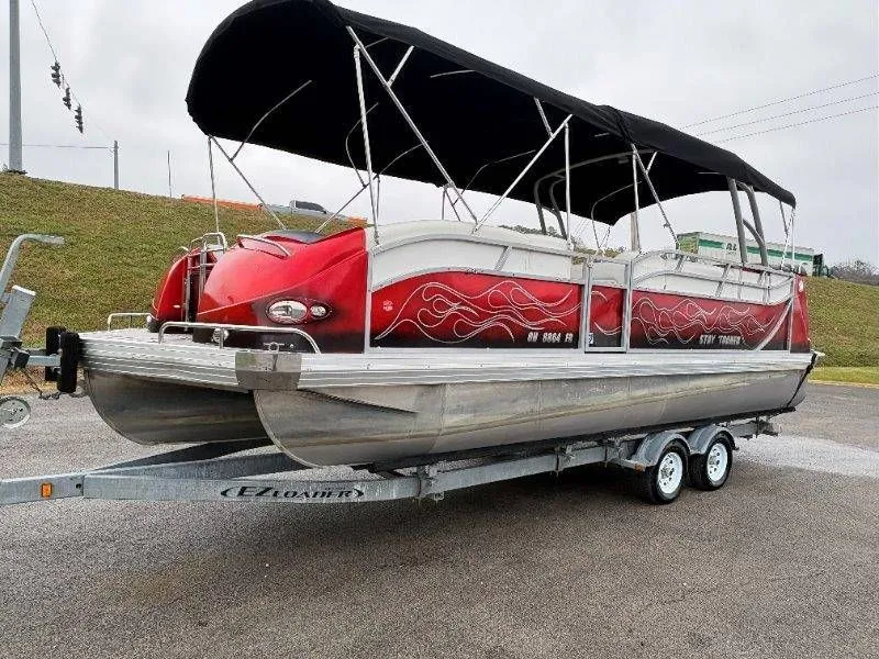 Slide: The Image of 2008 JC 246 IO pontoon boat on trailer with red design. - 15