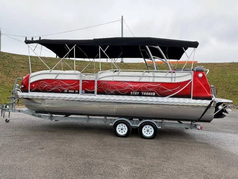 Slide: The Image of 2008 JC 246 IO pontoon boat with red design on trailer. - 17