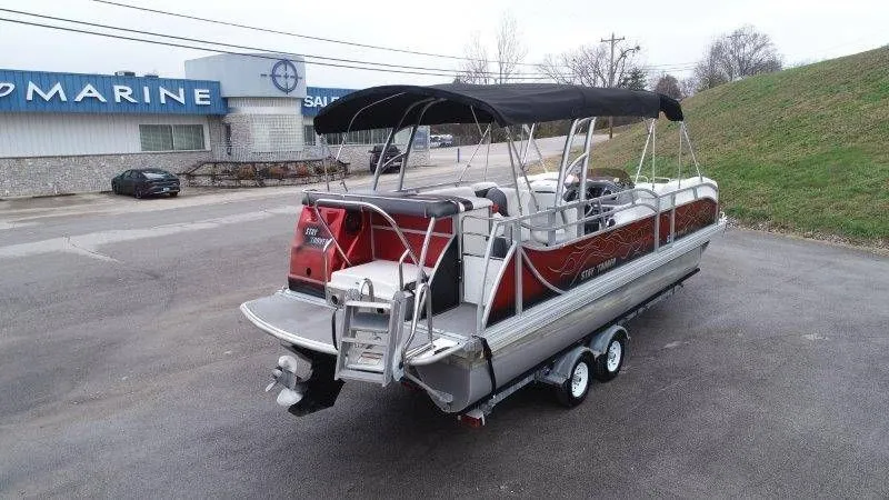 Slide: The Image of 2008 JC 246 IO pontoon boat on trailer outside a marine store. - 7
