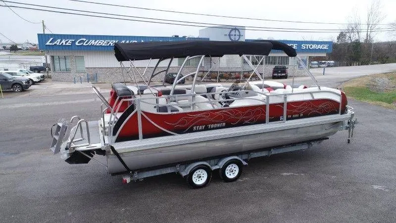Slide: The Image of Red 2008 JC 246 IO pontoon boat on trailer in front of storage building. - 9