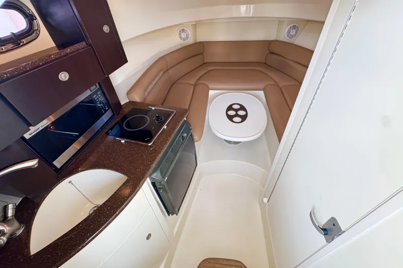 Slide: The Image of 2006 Boston Whaler 285 Conquest cabin interior with kitchenette and seating area. - 22