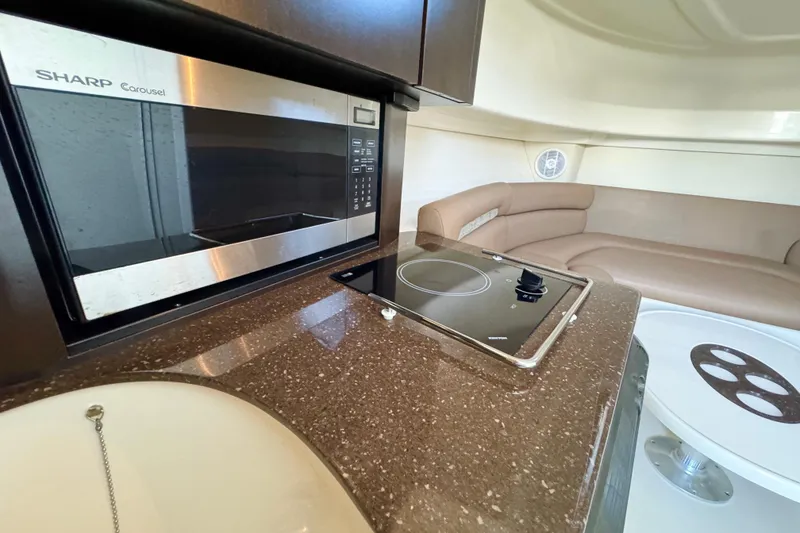 Slide: The Image of Interior of 2006 Boston Whaler 285 Conquest with microwave, cooktop, and seating area. - 24