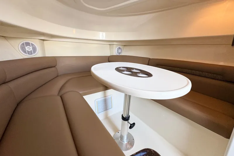 Slide: The Image of 2006 Boston Whaler 285 Conquest cabin interior with brown seating and white table. - 26