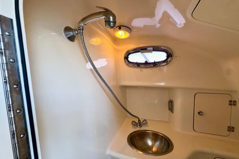 Slide: The Image of Interior of 2006 Boston Whaler 285 Conquest boat, featuring a compact bathroom with sink and shower. - 30