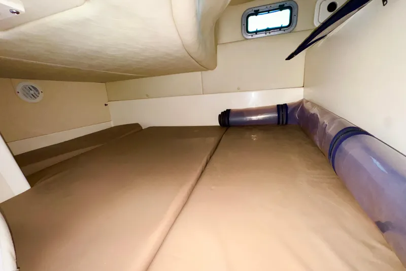 Slide: The Image of Interior cabin of 2006 Boston Whaler 285 Conquest boat, featuring a cozy sleeping area. - 32