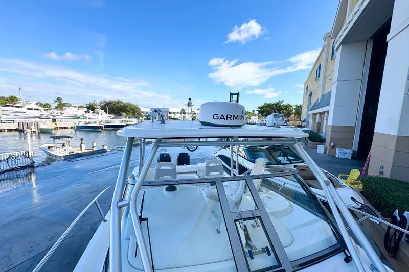 Slide: The Image of 2006 Boston Whaler 285 Conquest docked, featuring Garmin equipment, under a clear blue sky. - 37
