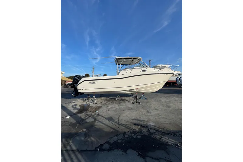 Slide: The Image of 2006 Boston Whaler 285 Conquest boat on stands under clear blue sky. - 38