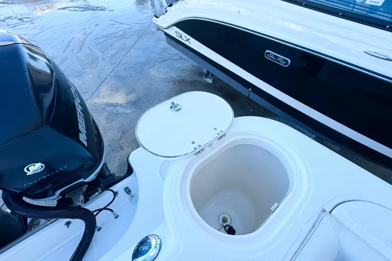 Slide: The Image of 2006 Boston Whaler 285 Conquest boat with open storage compartment and Mercury engine. - 6