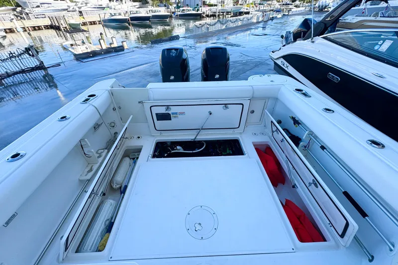 Slide: The Image of 2006 Boston Whaler 285 Conquest boat interior with storage compartments and twin engines. - 8