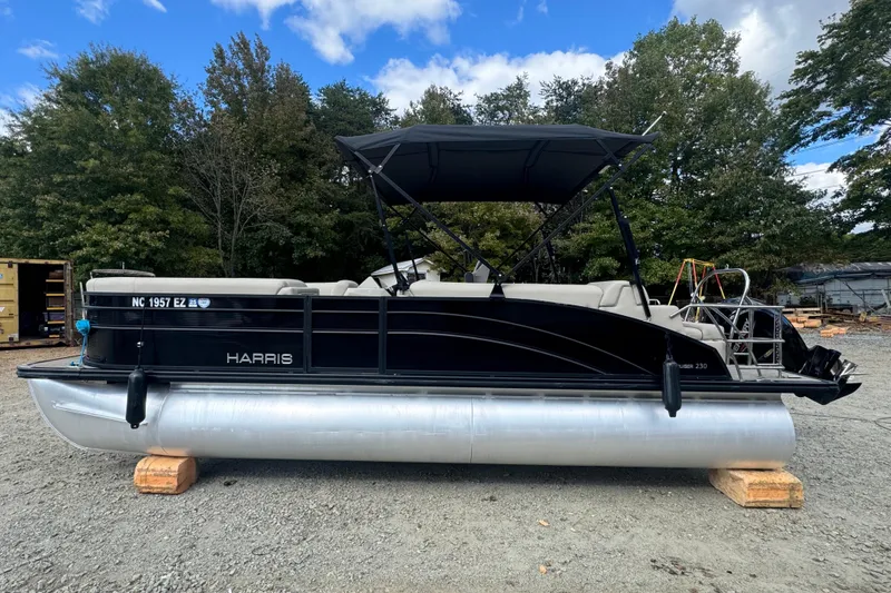 Slide: The Image of 2023 Harris HCX 230 Swingback pontoon boat on display outdoors. - 1