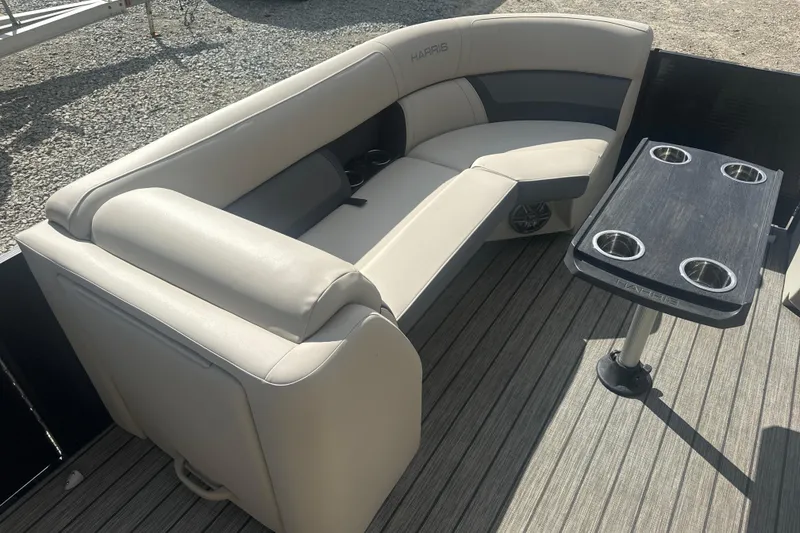 Slide: The Image of 2023 Harris HCX 230 Swingback boat interior with beige seating and table with cup holders. - 12