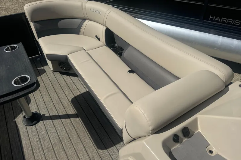 Slide: The Image of 2023 Harris HCX 230 Swingback boat interior with beige seating and cup holders. - 13
